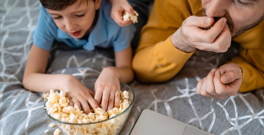 Beautiful happy family with child looking at laptop with cheerful smile at home
